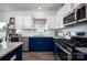 Modern kitchen with white cabinets, blue island, stainless steel appliances, and granite countertops at 116 Kingsway Dr, Mooresville, NC 28115