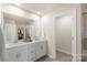 Bright bathroom featuring double vanity, a mirror, and a doorway to the toilet at 135 Orson Oaks Ln, Pineville, NC 28134