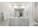 Stylish bathroom with double sinks, white cabinets, and ample lighting at 135 Orson Oaks Ln, Pineville, NC 28134