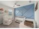 A well-lit Bedroom with a cozy chair, crib, and a unique accent wall at 135 Orson Oaks Ln, Pineville, NC 28134