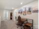 Loft space featuring a modern desk setup, carpet, and views from surrounding windows at 135 Orson Oaks Ln, Pineville, NC 28134