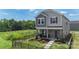 Two story home with gray siding, stone facade and a well manicured front yard with black metal fencing at 135 Orson Oaks Ln, Pineville, NC 28134