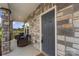 Covered front porch featuring stone columns, seating, and attractive front door at 135 Orson Oaks Ln, Pineville, NC 28134