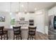 Bright kitchen features stainless appliances, stone counters, pendant lights, and bar stool seating at 135 Orson Oaks Ln, Pineville, NC 28134