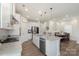 Bright kitchen features stainless appliances, stone counters, pendant lights, and a view to dining area at 135 Orson Oaks Ln, Pineville, NC 28134