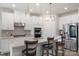 Bright kitchen features stainless appliances, stone counters, pendant lights, and bar stool seating at 135 Orson Oaks Ln, Pineville, NC 28134