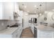 Bright kitchen features stainless appliances, stone counters, pendant lights, and bar stool seating at 135 Orson Oaks Ln, Pineville, NC 28134