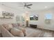Bright living room featuring a large sectional sofa, decorative shelving, and ample natural light at 135 Orson Oaks Ln, Pineville, NC 28134