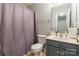 Standard bathroom with a shower featuring a violet curtain, a functional toilet, and essential toiletries on the vanity at 14755 Lions Paw St, Charlotte, NC 28273