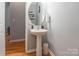 This half-bathroom features a classic pedestal sink and modern wall decor, and neutral paint at 14755 Lions Paw St, Charlotte, NC 28273
