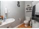 A well-lit half-bathroom includes a pedestal sink, decorative shelving, and neutral wall paint at 14755 Lions Paw St, Charlotte, NC 28273