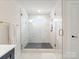 This bathroom features a glass-enclosed shower with modern gold fixtures and marble tiling at 1517 Falcon St, Charlotte, NC 28211