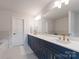 Bathroom features a blue double vanity, sleek white countertop, and modern gold fixtures at 1517 Falcon St, Charlotte, NC 28211