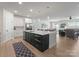 Open-concept kitchen featuring a large island with seating, stainless steel appliances, and an open view to the living room at 1517 Falcon St, Charlotte, NC 28211