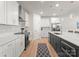 Modern kitchen with white cabinets, stainless steel appliances, a large island with pendant lighting, and wood floors at 1517 Falcon St, Charlotte, NC 28211