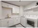 This laundry room features white cabinets, countertop space, and modern washer/dryer at 1517 Falcon St, Charlotte, NC 28211