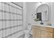 Stylish bathroom with a modern vanity, decorative mirror, and shower with patterned curtain at 18027 Wilbanks Dr, Charlotte, NC 28278