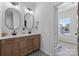 Well-lit bathroom with double vanity, modern fixtures, and a view of a pretty yard at 18027 Wilbanks Dr, Charlotte, NC 28278