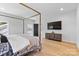 Well-lit bedroom with a four-poster bed, hardwood floors, and a TV on the credenza at 18027 Wilbanks Dr, Charlotte, NC 28278