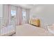 Charming Bedroom with pink accents, a crib, dresser, and sun-filled windows at 18027 Wilbanks Dr, Charlotte, NC 28278