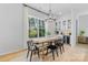 Modern dining area with natural light, stylish chandelier, built-in cabinetry, and hardwood floors at 18027 Wilbanks Dr, Charlotte, NC 28278