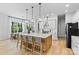 Bright, modern kitchen with large island, quartz countertops, stainless steel appliances, and hardwood floors at 18027 Wilbanks Dr, Charlotte, NC 28278