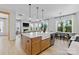 Open kitchen with kitchen island bar, stainless steel appliances, hardwood floors, and open concept living area at 18027 Wilbanks Dr, Charlotte, NC 28278