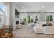 Spacious living room featuring large windows, a fireplace, and an expansive white sectional sofa at 18027 Wilbanks Dr, Charlotte, NC 28278