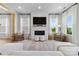 Cozy living room with a white brick fireplace, large windows, and comfortable seating arrangements at 18027 Wilbanks Dr, Charlotte, NC 28278