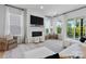 Bright living room with a white brick fireplace, large windows, and elegant furnishings at 18027 Wilbanks Dr, Charlotte, NC 28278