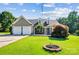 Charming single Gathering home featuring a two-car garage and manicured lawn with flowering shrubbery and a proud American flag at 181 Brook Glen Dr # 56, Mooresville, NC 28115