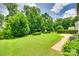 Expansive backyard featuring manicured lawn, mature trees, and peaceful ambiance, perfect for outdoor activities at 1930 Caprington Dr, Fort Mill, SC 29707