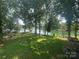 A spacious, grassy backyard with mature trees and a view of the lake at 195 Keats Rd, Mooresville, NC 28117