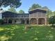 Back exterior of the house with screened porches, lower patio, fire pit, and a swing at 195 Keats Rd, Mooresville, NC 28117