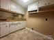 Practical laundry room with overhead cabinets, sink, and vinyl flooring at 195 Keats Rd, Mooresville, NC 28117