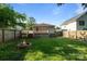 A serene backyard features a fire pit and well-maintained lawn, enclosed by a wooden fence for privacy and security at 215 Cedar St, Belmont, NC 28012