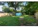 A fenced backyard features a fire pit and a storage shed, perfect for outdoor gatherings and storage solutions at 215 Cedar St, Belmont, NC 28012