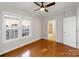 Well-lit bedroom with hardwood floors and two windows; bathroom doorway visible in the background at 215 Cedar St, Belmont, NC 28012