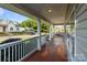 Inviting covered front porch with wood flooring and white railing, perfect for relaxing outdoors at 215 Cedar St, Belmont, NC 28012