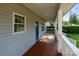 Covered front porch featuring wood flooring and white railings, with ample space and natural light at 215 Cedar St, Belmont, NC 28012