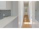 Long hallway leads to bathroom and provides kitchen views with hardwood flooring and modern paint at 215 Cedar St, Belmont, NC 28012
