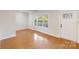 Well-lit living room with hardwood floors and a stylish front door, offering a welcoming and modern space at 215 Cedar St, Belmont, NC 28012