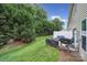 Green backyard features trees, a grill with cover, and patio seating at 2203 Whitford Ln, Charlotte, NC 28210