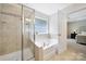 Bright bathroom featuring a tiled shower, soaking tub and tiled surround at 2203 Whitford Ln, Charlotte, NC 28210