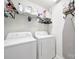 Bright laundry room featuring white appliances, overhead storage shelf, and convenient ironing board setup at 2203 Whitford Ln, Charlotte, NC 28210