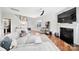 Bright and airy living room featuring hardwood floors, a plush grey sectional sofa, and a cozy fireplace, perfect for relaxation at 2203 Whitford Ln, Charlotte, NC 28210