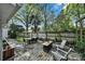 Charming backyard with brick patio featuring outdoor seating and wooden privacy fence surrounded by mature trees at 2314 Wolfe St, Charlotte, NC 28205