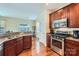 Spacious kitchen featuring stainless steel appliances, dark wood cabinets, granite countertops, and hardwood flooring at 2630 Filson Ct, Charlotte, NC 28214