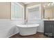 Bright bathroom with modern fixtures, glass block windows, soaking tub, and dark wood flooring at 267 Winthrow Creek Rd, Mooresville, NC 28115