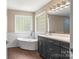 Bright bathroom with modern fixtures, glass block windows, soaking tub, and dark wood flooring at 267 Winthrow Creek Rd, Mooresville, NC 28115